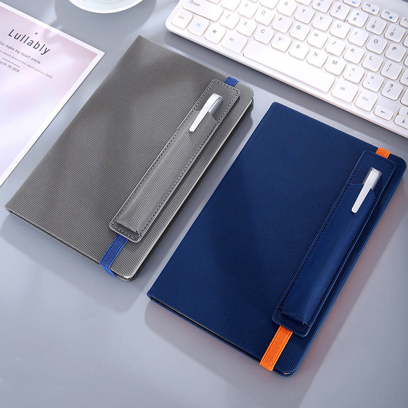 Grey and navy notebooks next to a keyboard